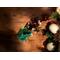 Sunlight illuminates a sachet of Nana's Apple Pie potpourri on a brown table with nearby ornaments and stark shadows in the background.